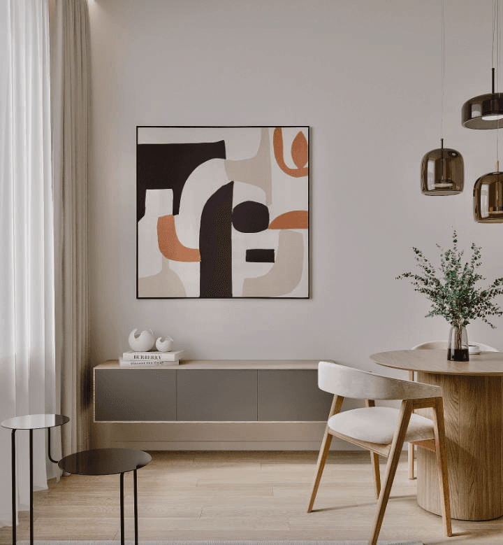 A wooden dining table, light-coloured chairs, pendant lights and abstract wall art.