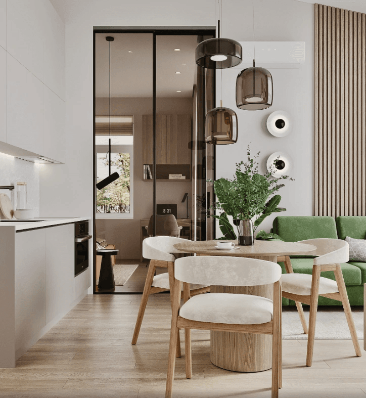 Interior design image of an open living area with white kitchen cabinets, a round dining table and a green sofa.